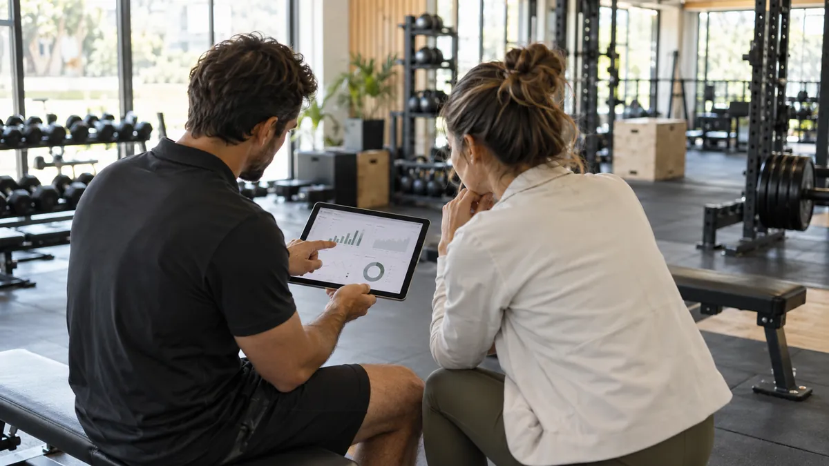 Consultoría de gimnasios: consultor y propietario revisando datos de un centro deportivo